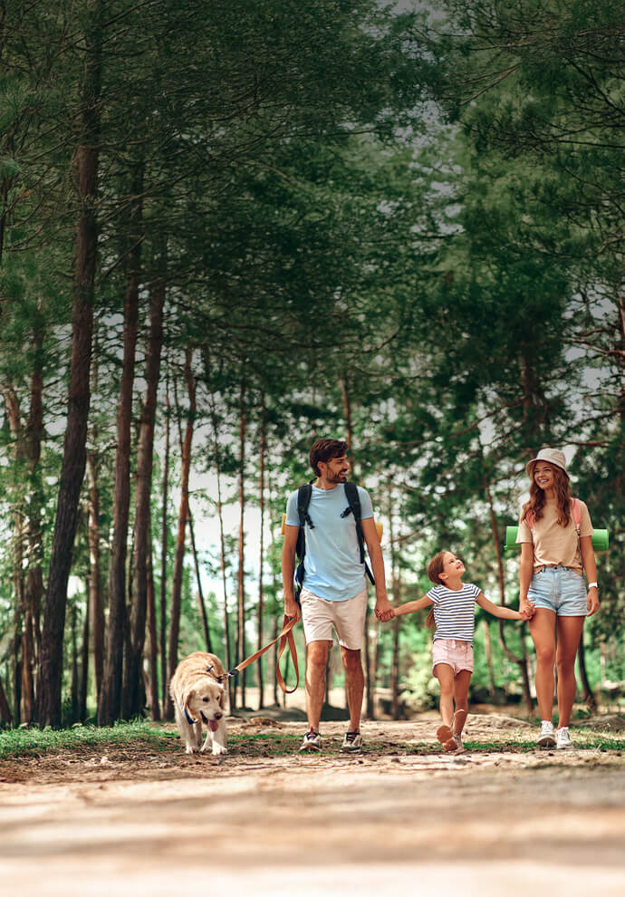 Famiglia con cane che passeggia nel bosco