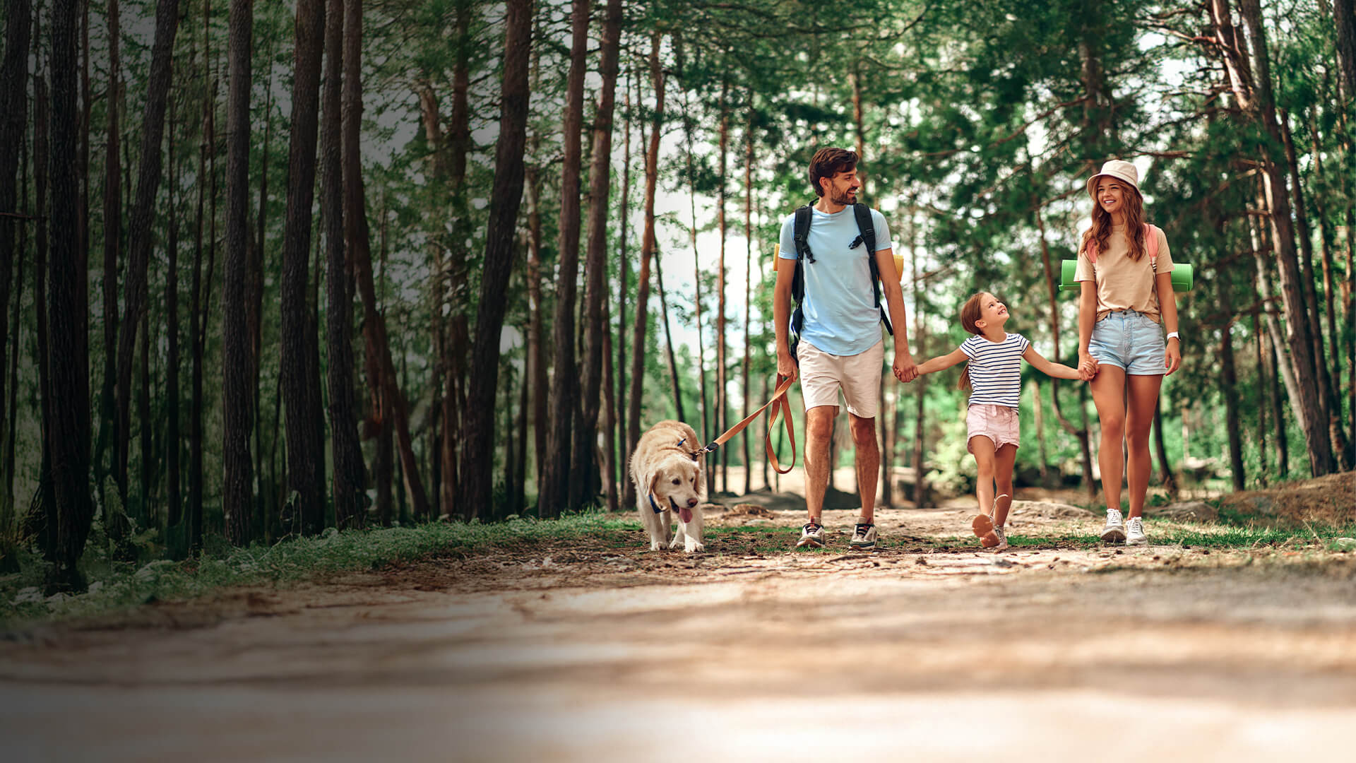 Famiglia con cane che passeggia nel bosco